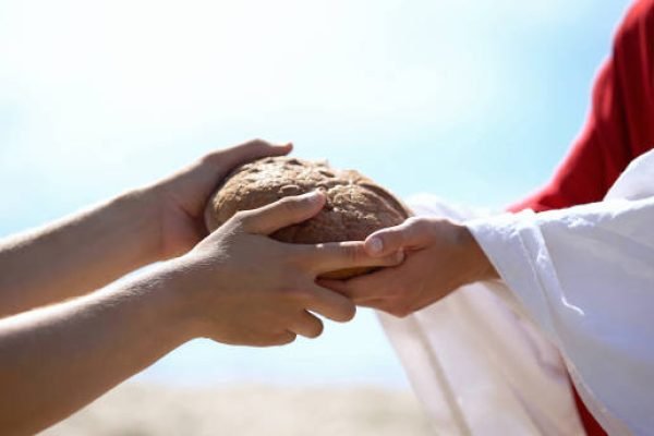 Jesus hands giving bread to poor man, biblical story to feed hungry, charity